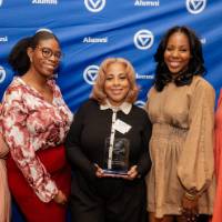 Khadijah Johnson smiles holding her award next to friends